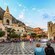 The bustling town square of Taormina in Sicily, Italy, complete with age-old churches and people dining at outdoor cafés